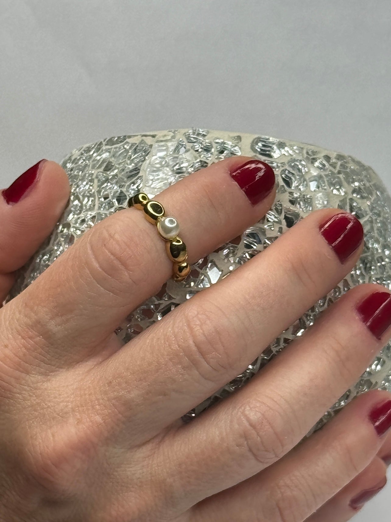 Anillo Perla Mini dorado con microesferas y perla blanca en mano