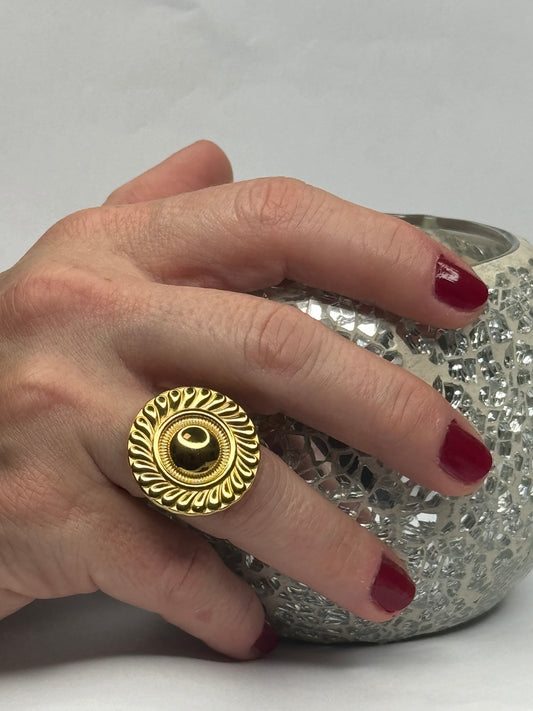 Anillo Atenea medallón dorado ajustable en mano con relieve trenzado