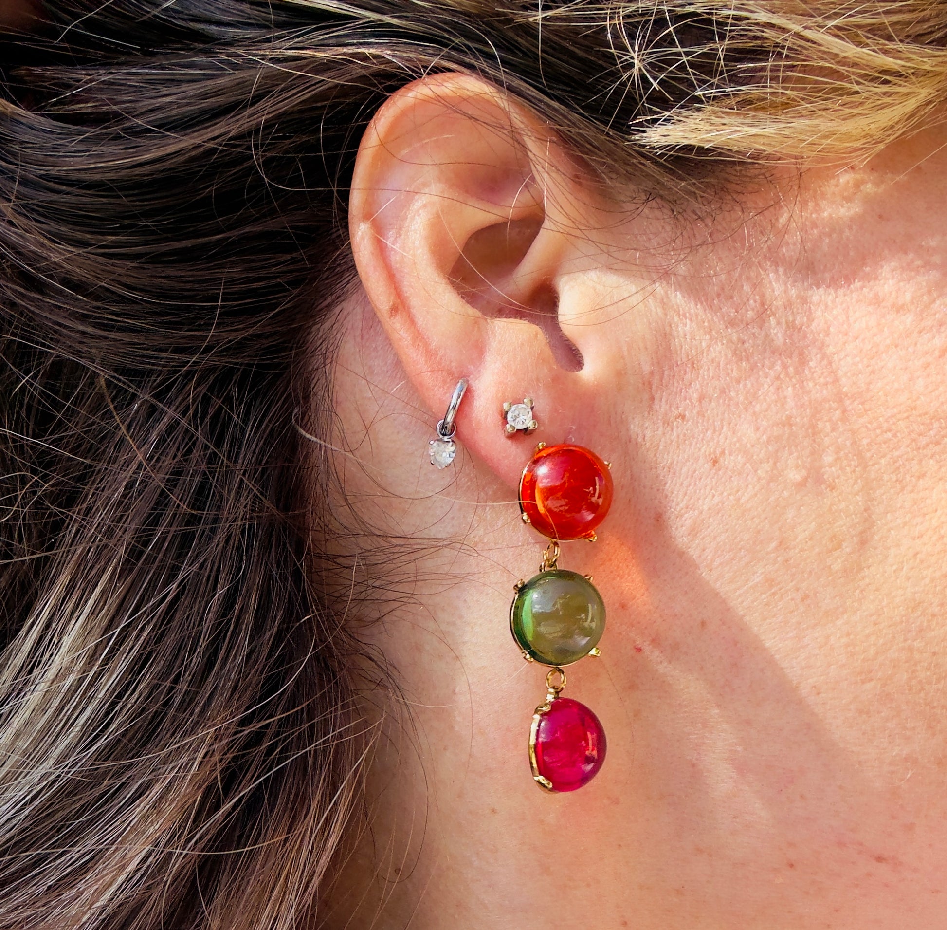 Pendientes Candy en modelo, tres cabujones rojo verde y fucsia con herrajes dorados